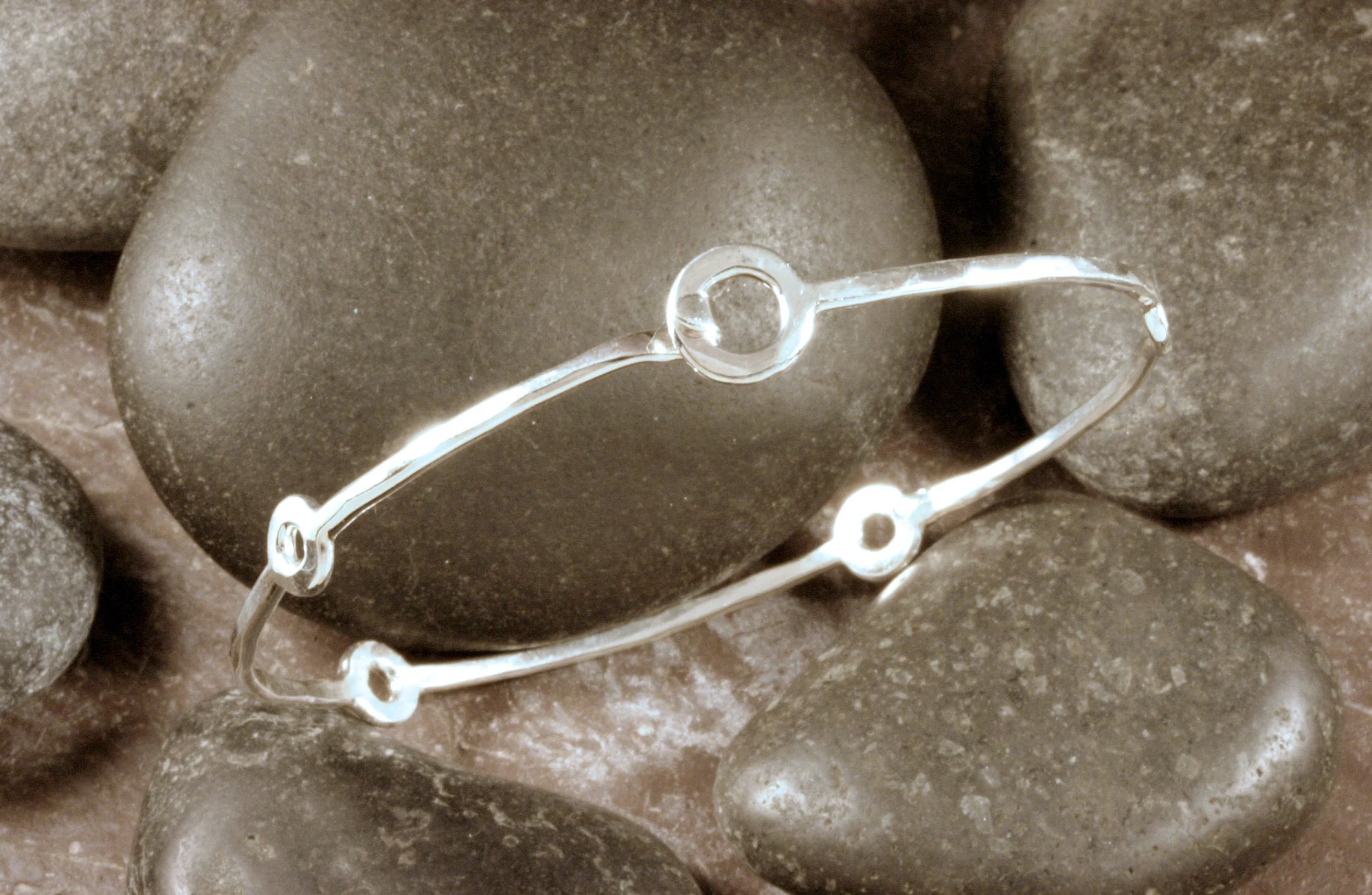 A hammered sterling silver fitted station bangle bracelet with a loop and hook clasp.