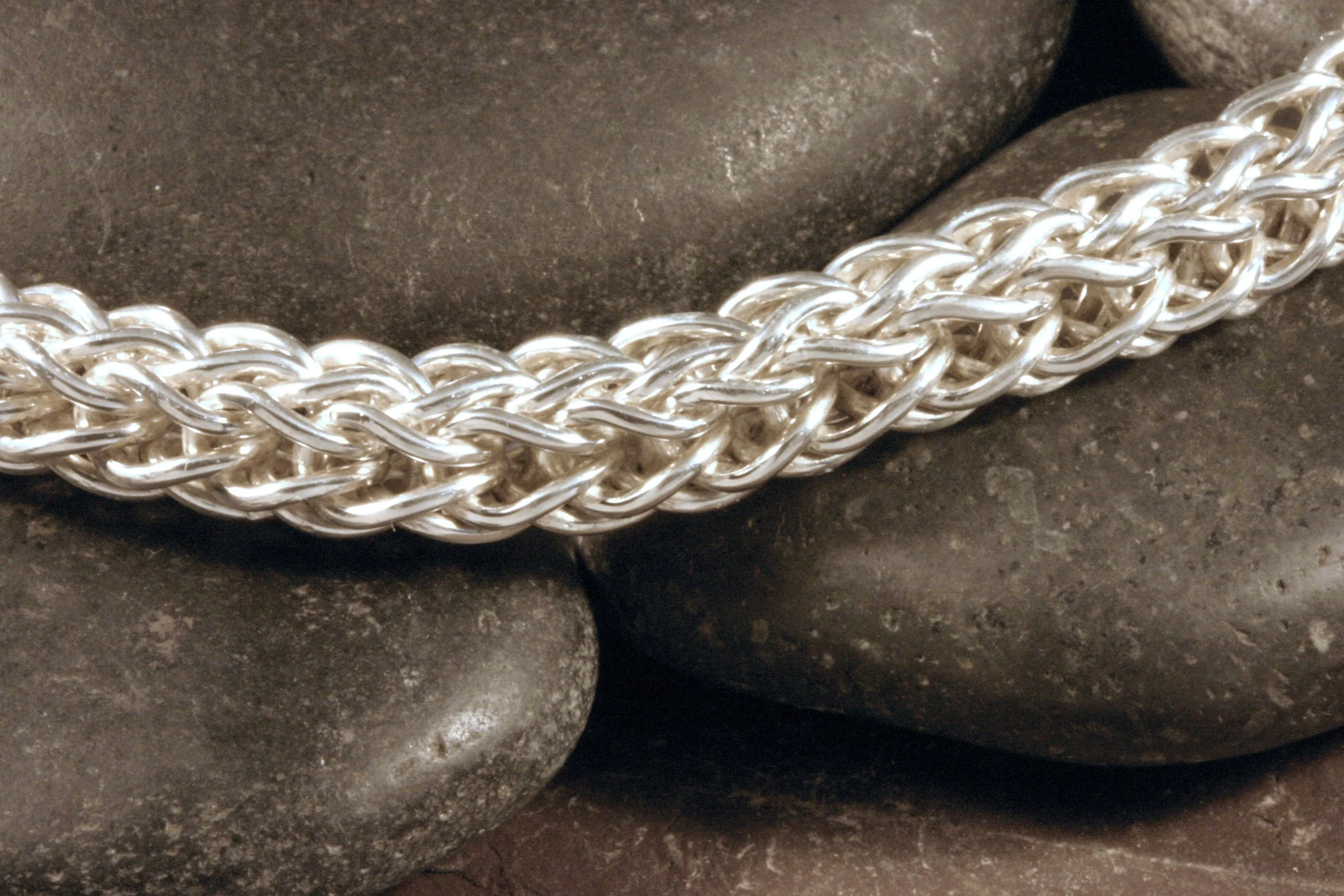 A detail image of a handmade sterling silver 2 way loop in loop chain bracelet.