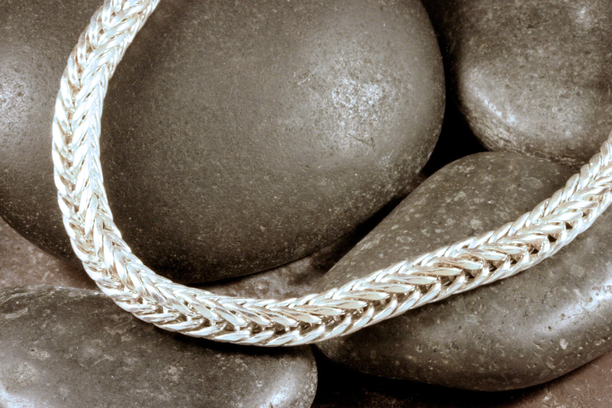 A detail image of the links in a handmade sterling silver square double loop in loop chain necklace.