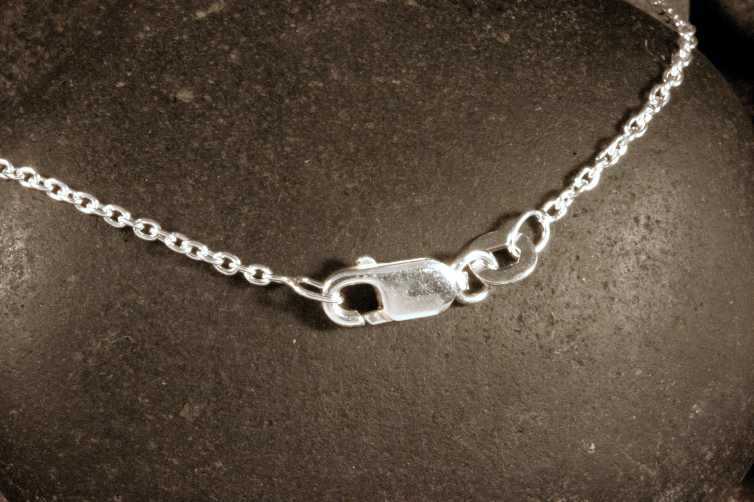 A lobster clasp on a sterling silver 1.5 mm cable chain.