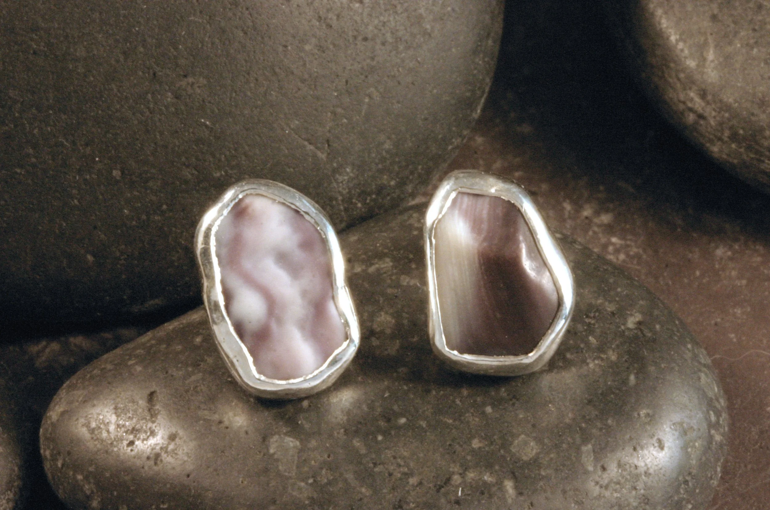 A front view of small sterling silver freeform pentagon wampum stud earrings.