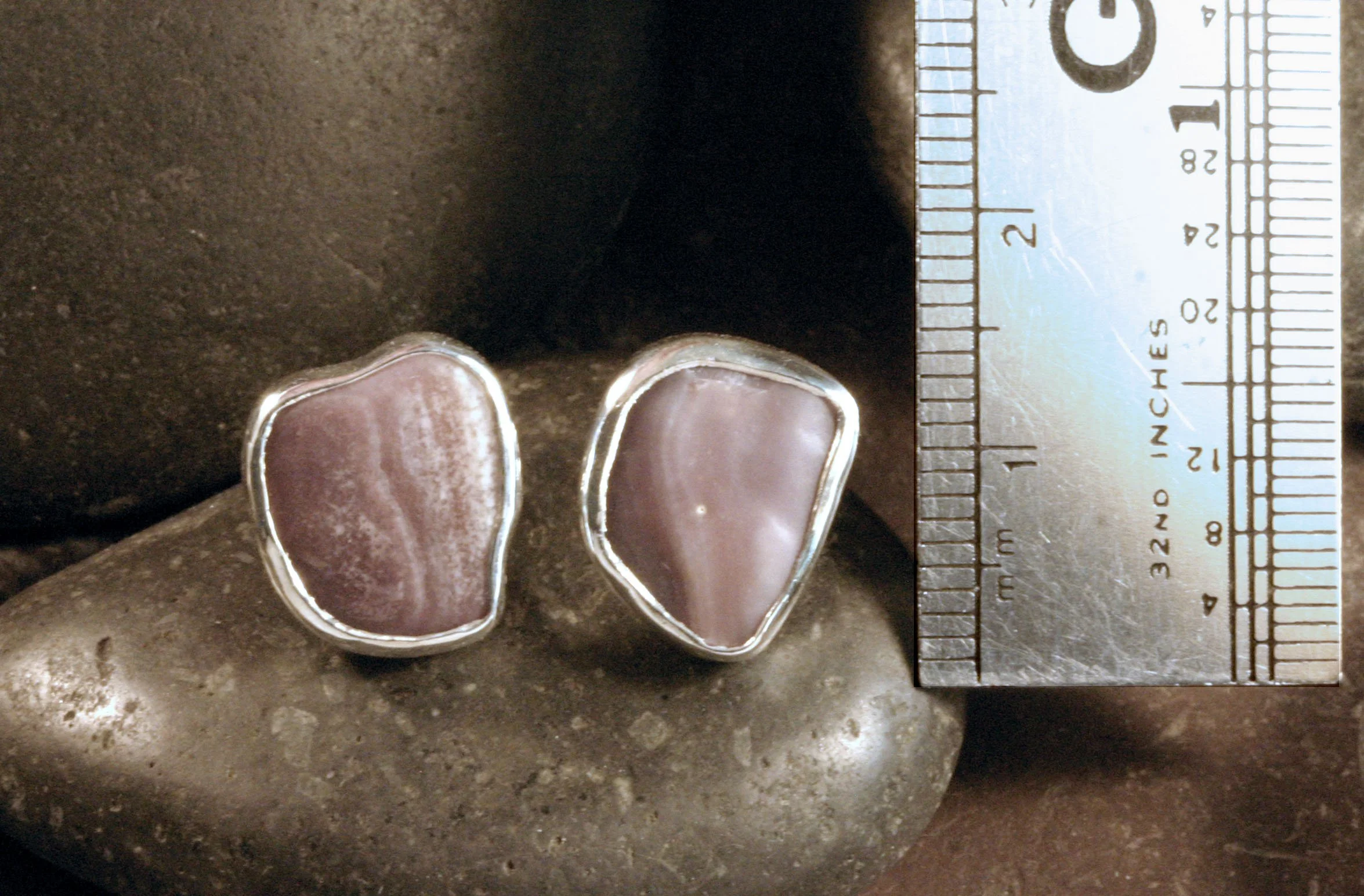 Small sterling silver freeform wampum studs next to a ruler.