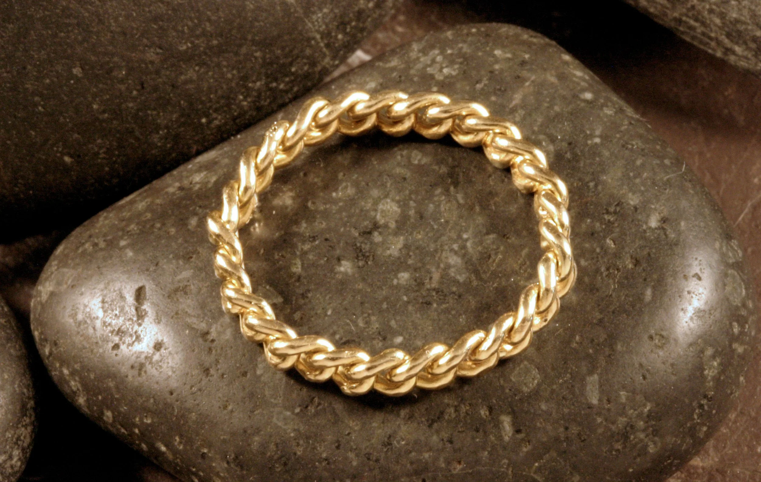 A top view of a 14K gold curb chain ring positioned in a circle.
