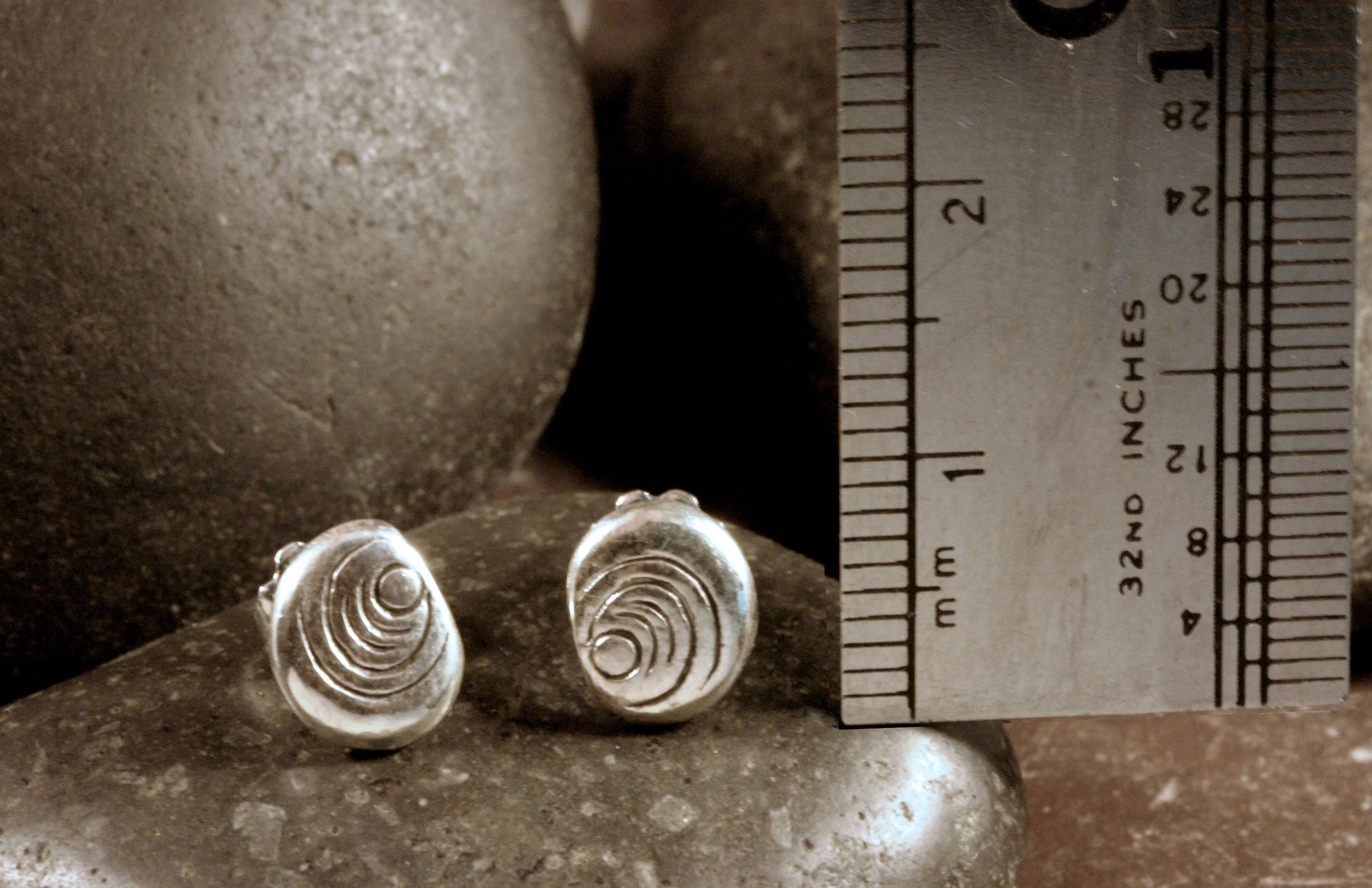 Sterling silver dot ripple pattern stud earrings next to a ruler.