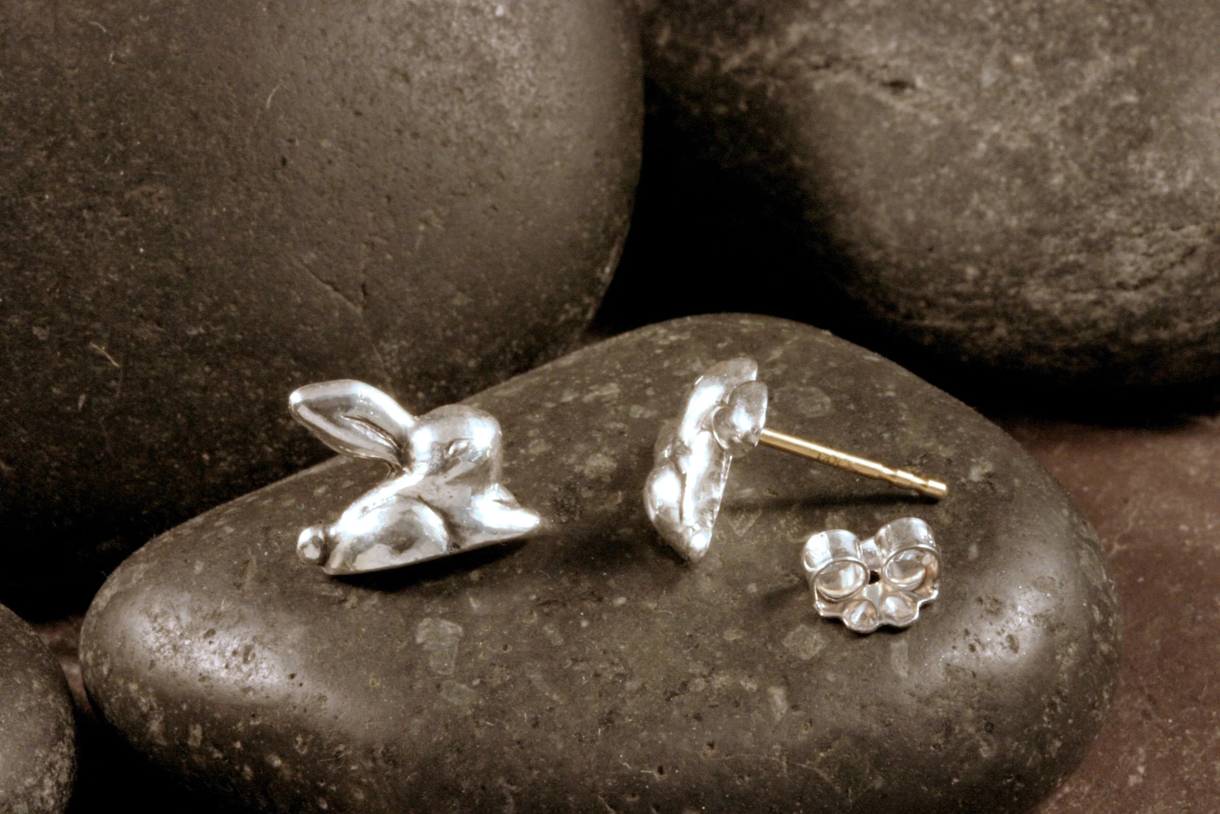 A side view of sterling silver rabbit stud earrings with hypoallergenic 14K gold posts.