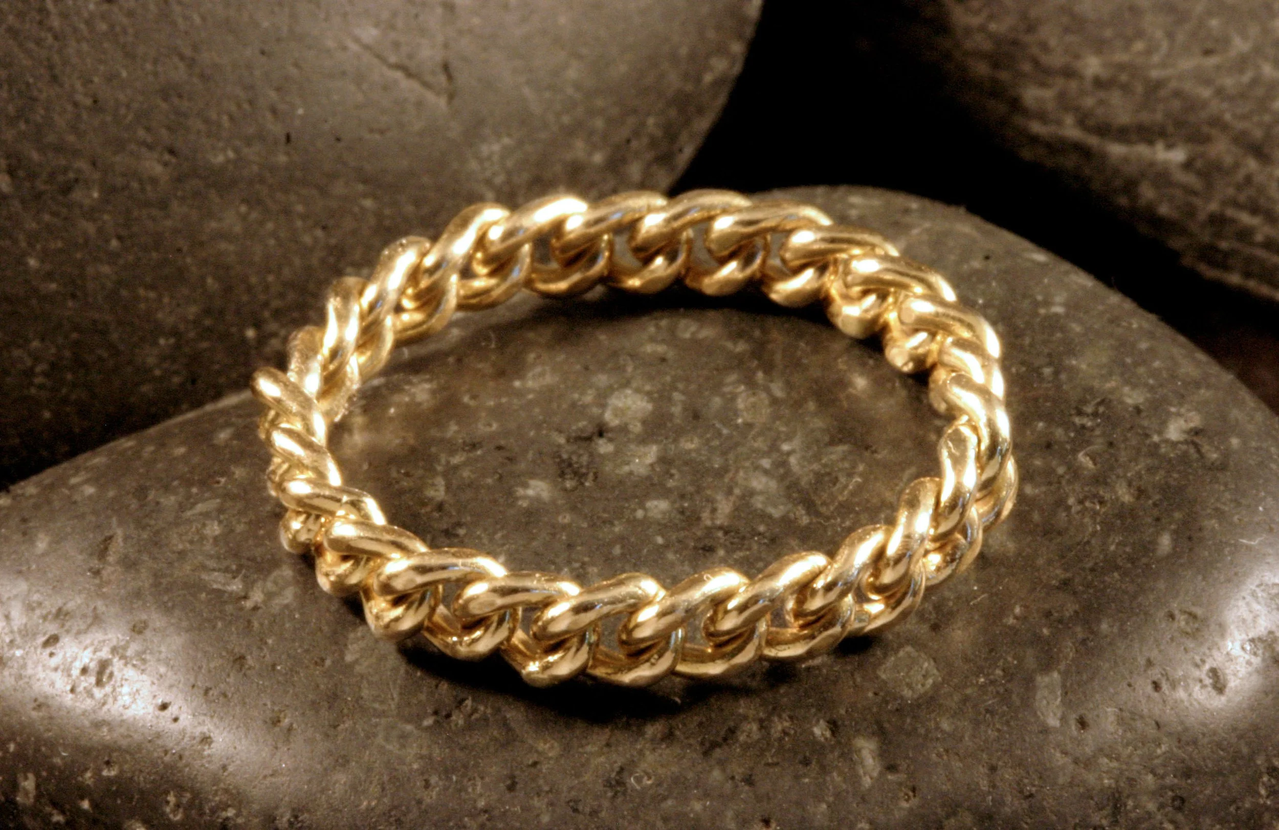 A 14K yellow gold handwoven curb chain ring.