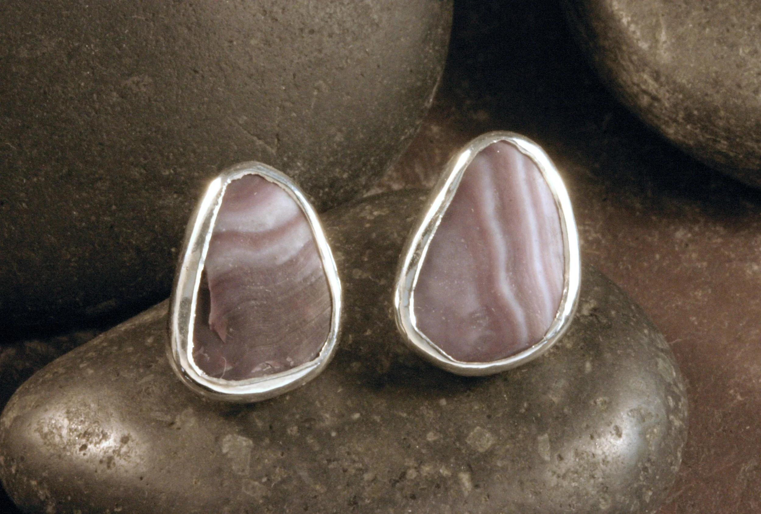 A front view of small sterling silver triangle wampum stud earrings.
