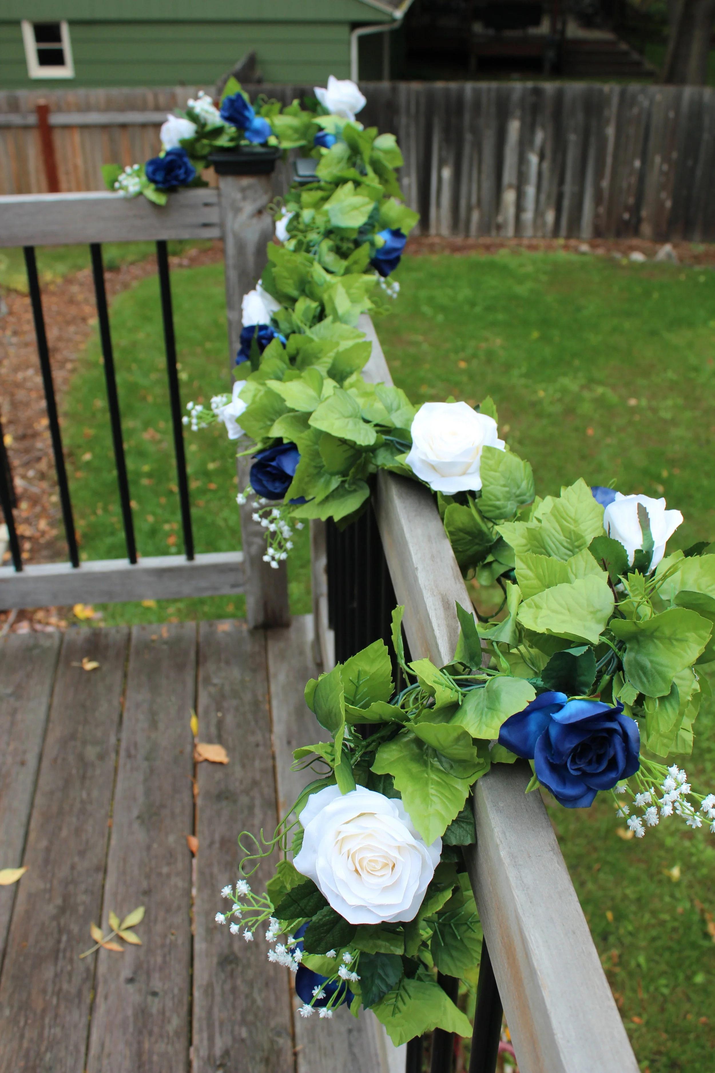 8 foot garland for the head table: blue roses, ivory roses, baby’s breath, ivy.