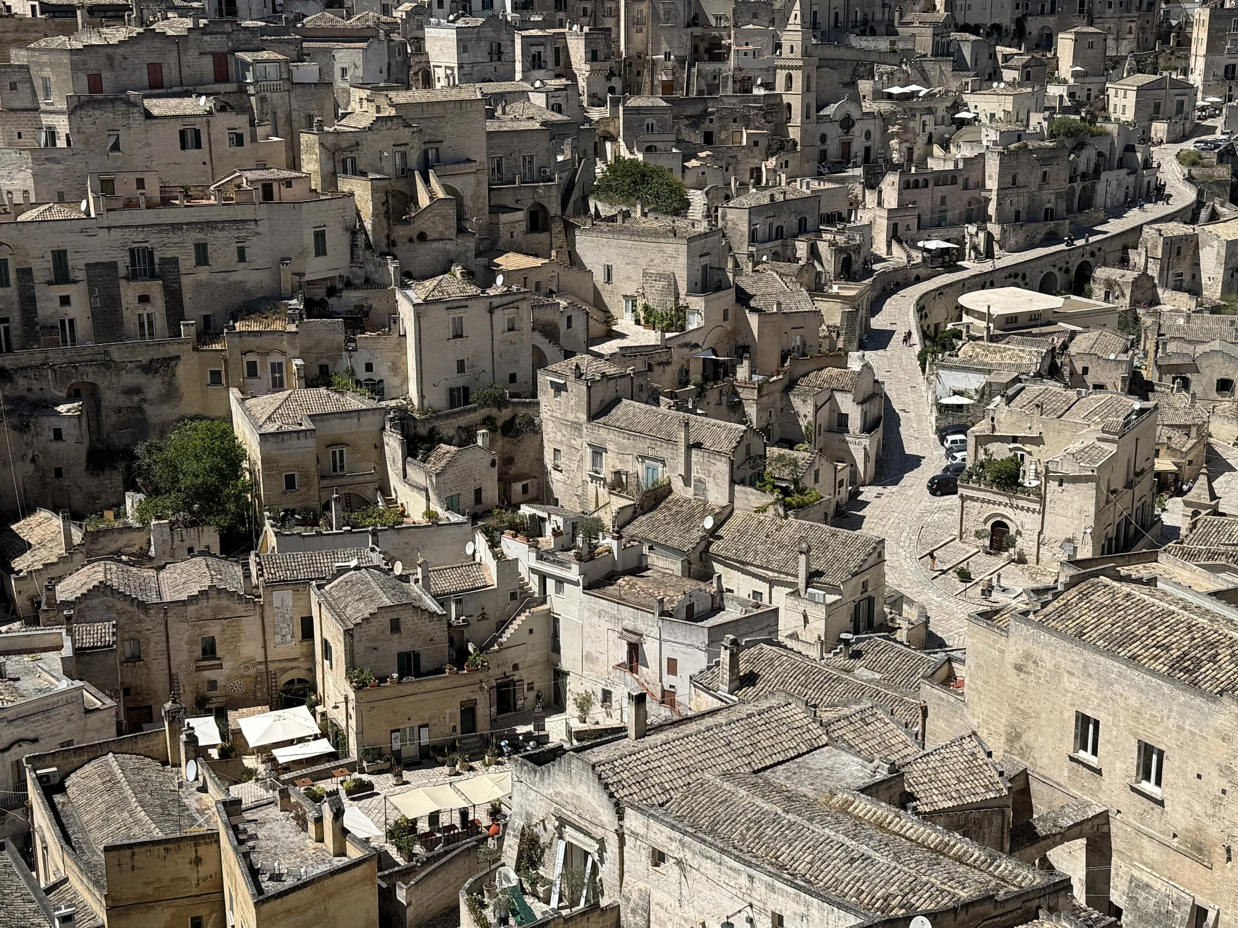 A dense view of an old European city with many closely packed stone buildings and narrow winding streets, likely taken from a high vantage point.