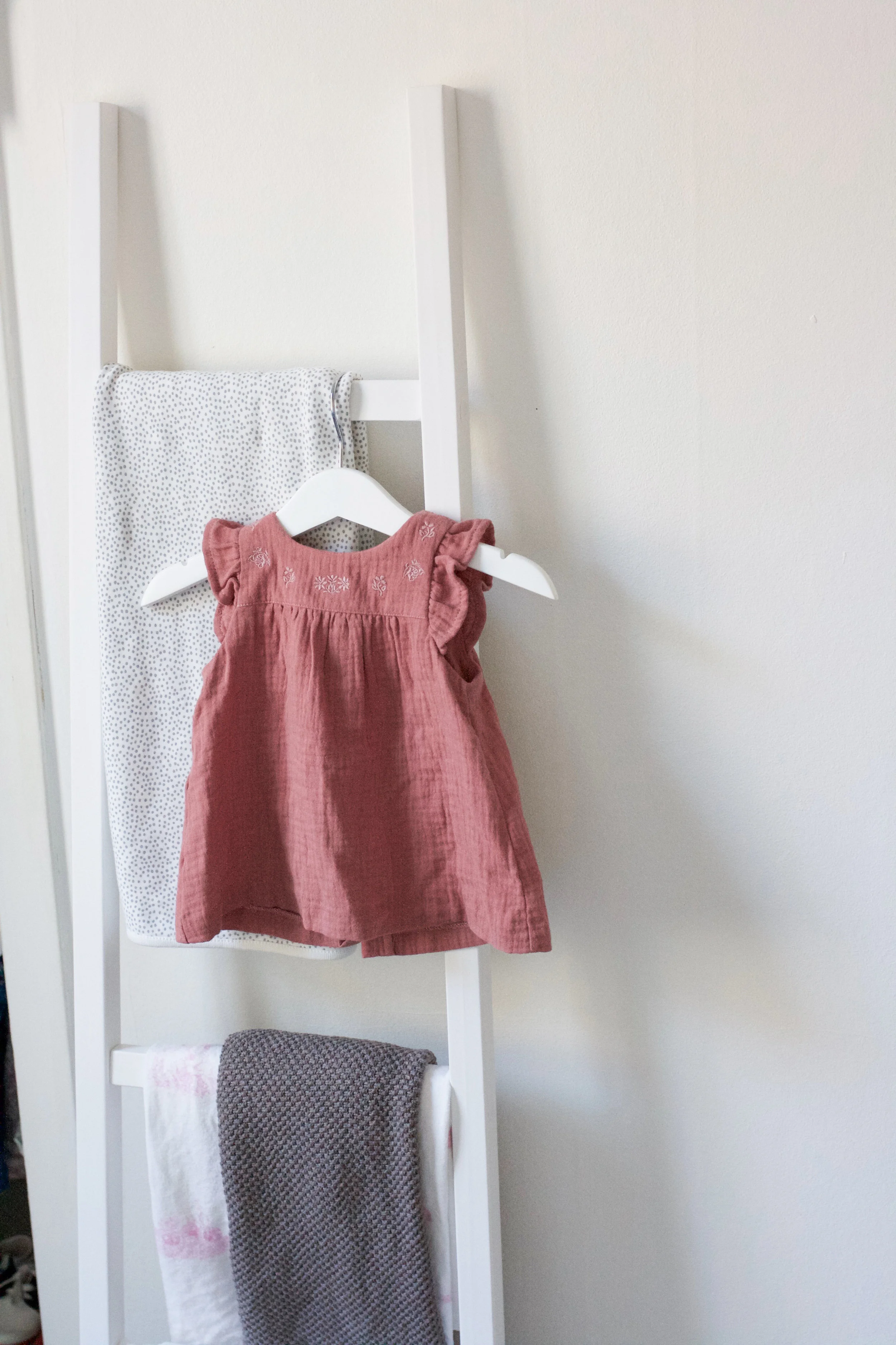 So many cozy blankets and dainty dresses--I wish I could display them all!