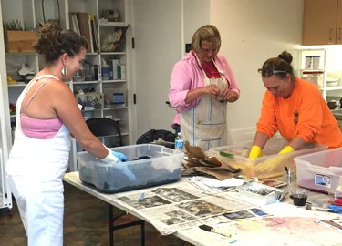 Students submerging fabric in dye