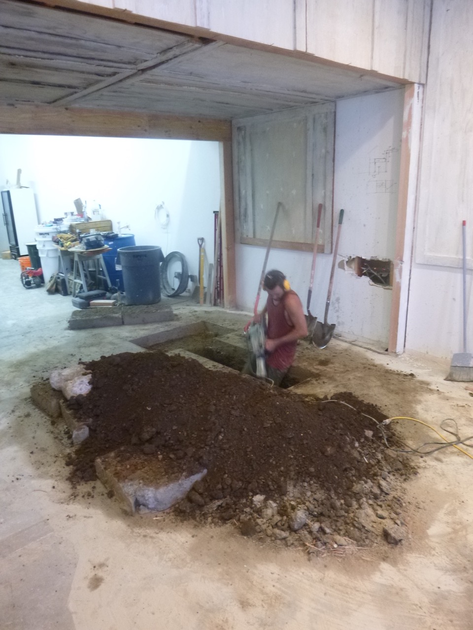 In search of the building's main drain line: Creative director, brewmaster, and owner Nole Cossart digging deep. Note the salvaged wall panels from discarded furniture storage units.