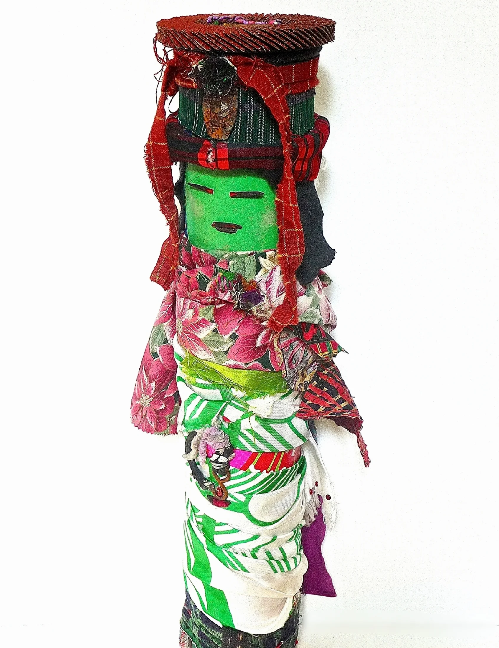 Green Foreigner Recycled textiles, rust, sanding disk, paint, acrylic gel,, paper, yarn, metal, plastic, wood, elastic, glitter, and found objects on industrial cardboard tube 22 x 8” round 2015