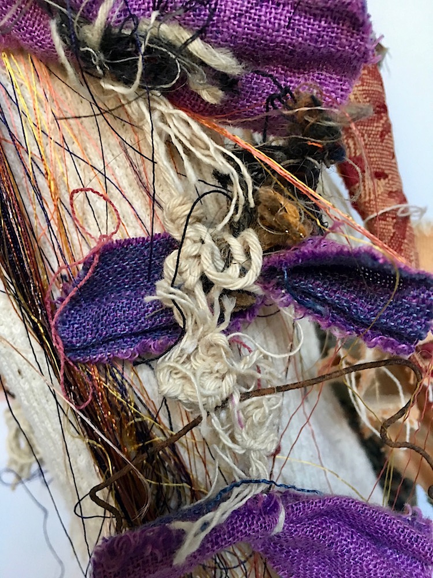 Mirror Eye (Detail) Recycled textiles, mirrors, rust, elastic, string, paint, thread, button, needle, nylon, rag rug, acrylic, beads, found felt, wool, purple bow necklace stitched on train, cement, paper, on industrial cardboard tube 32 x 7½” round 2017