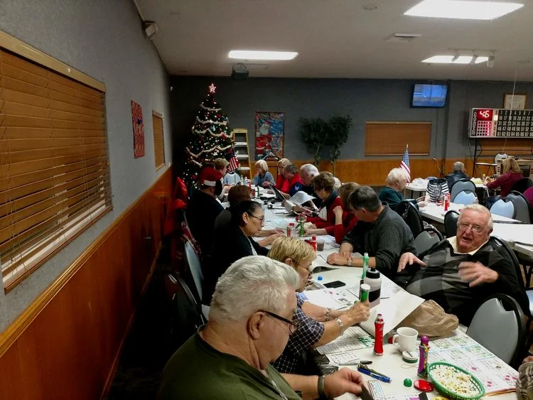 Tom King trying to explain the workings of “Bingo.” Next to Tom is Ken "Doc" Honaker and his wife Sue. Across from them are Val Galvan and Toni Trotman, with Chaplain Brad Cantley in the funny hat.