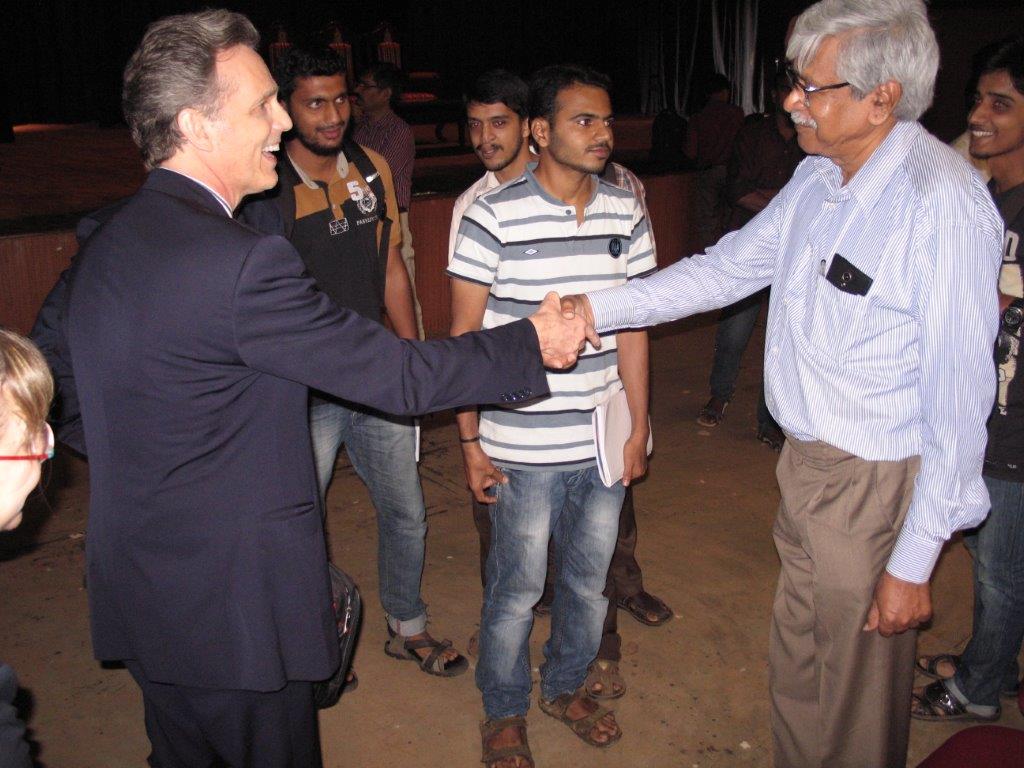 David Wiebers, M.D., shaking hands with physics professor at Mangalore University. 