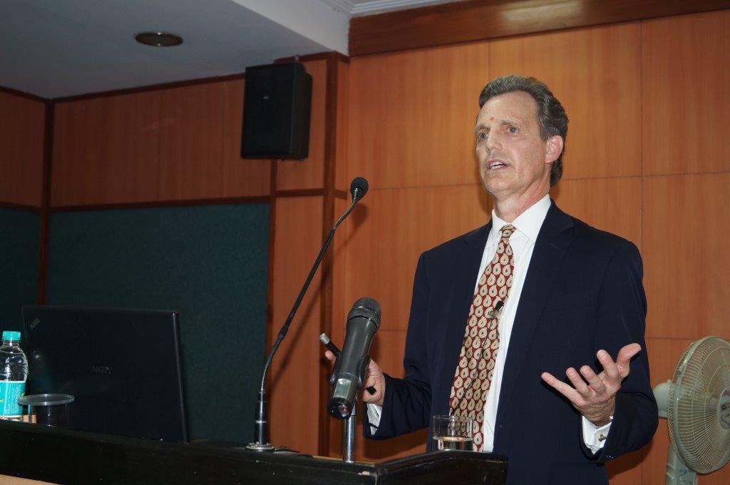David Wiebers, M.D., at the podium at Amity University Delhi campus delivering Theory of Reality presentation on November 9, 2015.