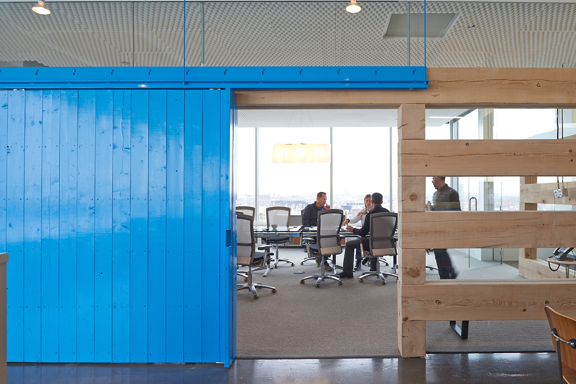   Reusable rough-sawn lumber defines a meeting room with salvaged barn doors.   