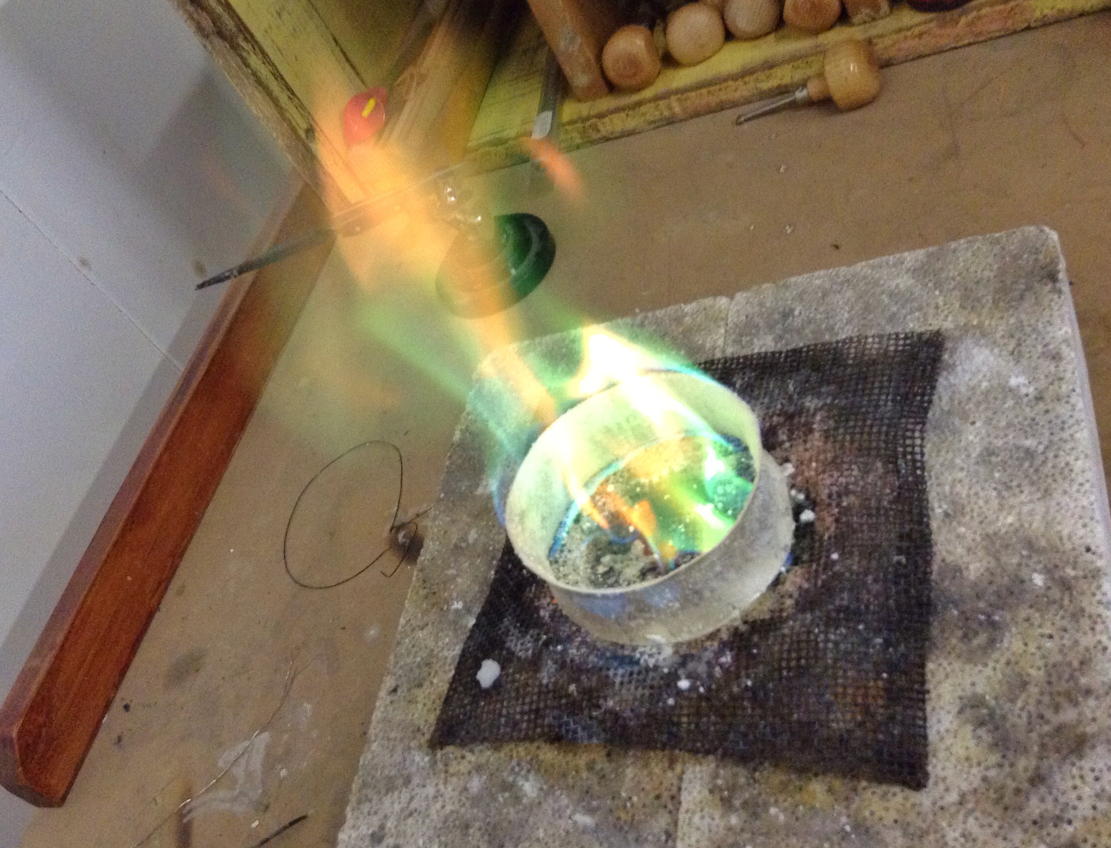 Burning off a resist powder applied to the metal before annealing (softening to forge). The powder helps with resisting a stain on silver known as firescale.