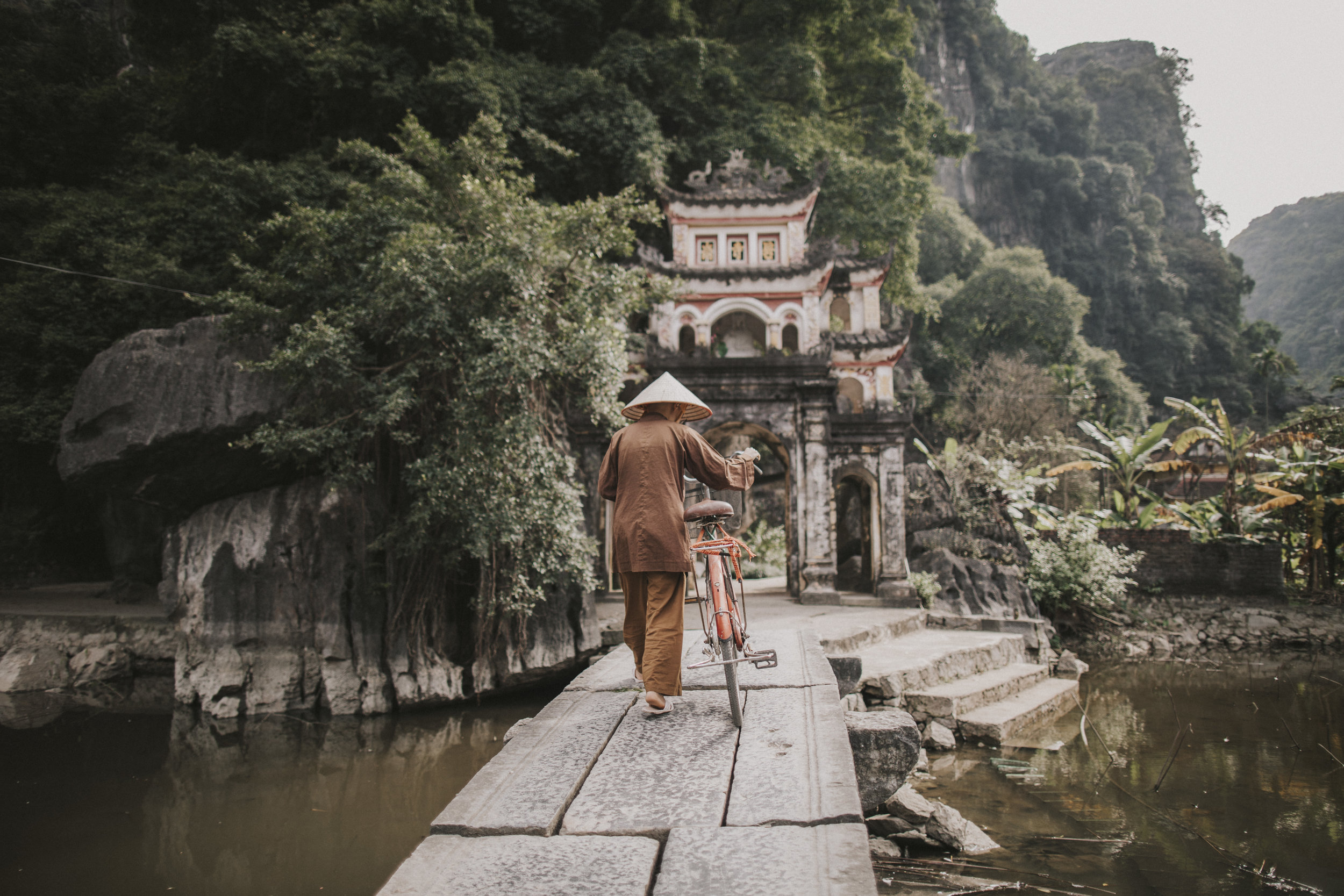 Monk on bridge in Tamcoc