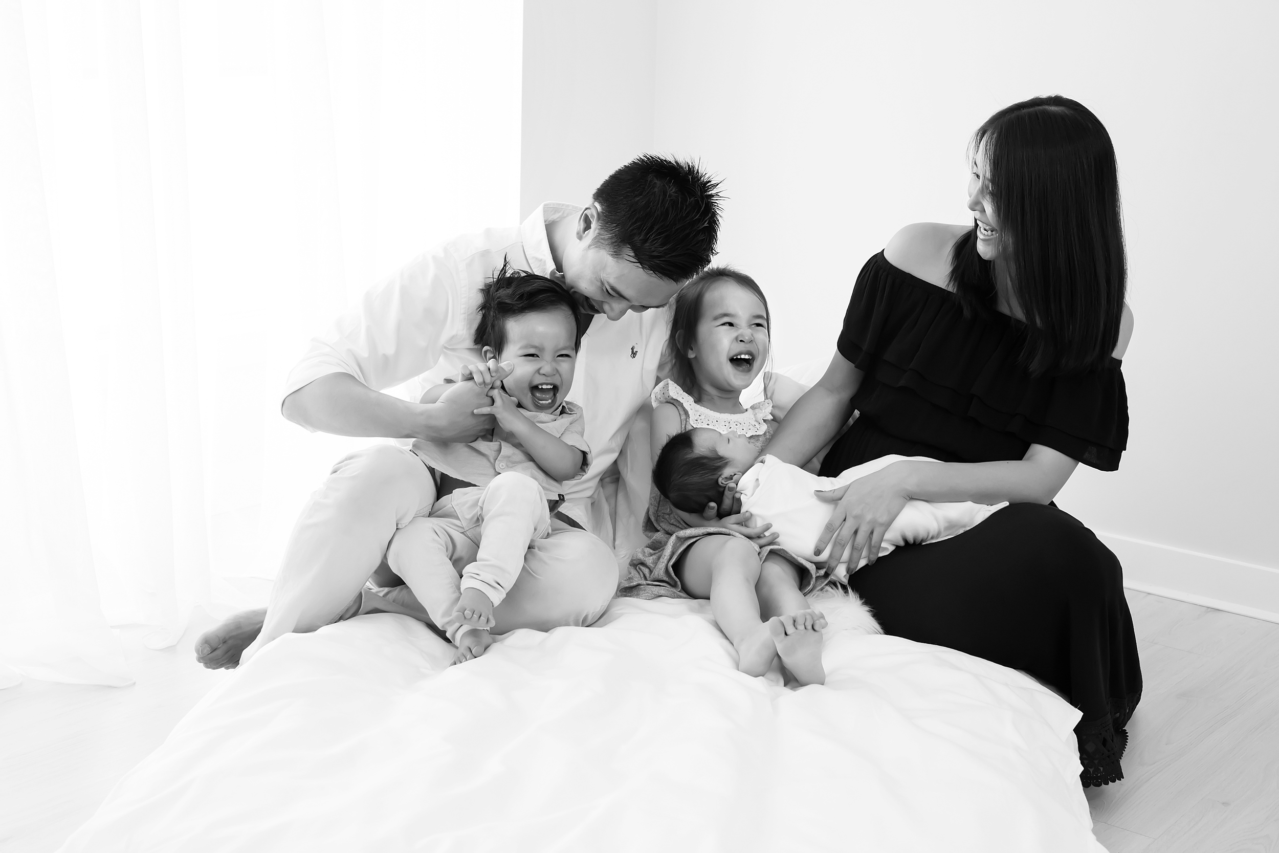 A candid photo of a Melbourne family with their newborn baby taken by Melbourne newborn photographer, Monique Graham