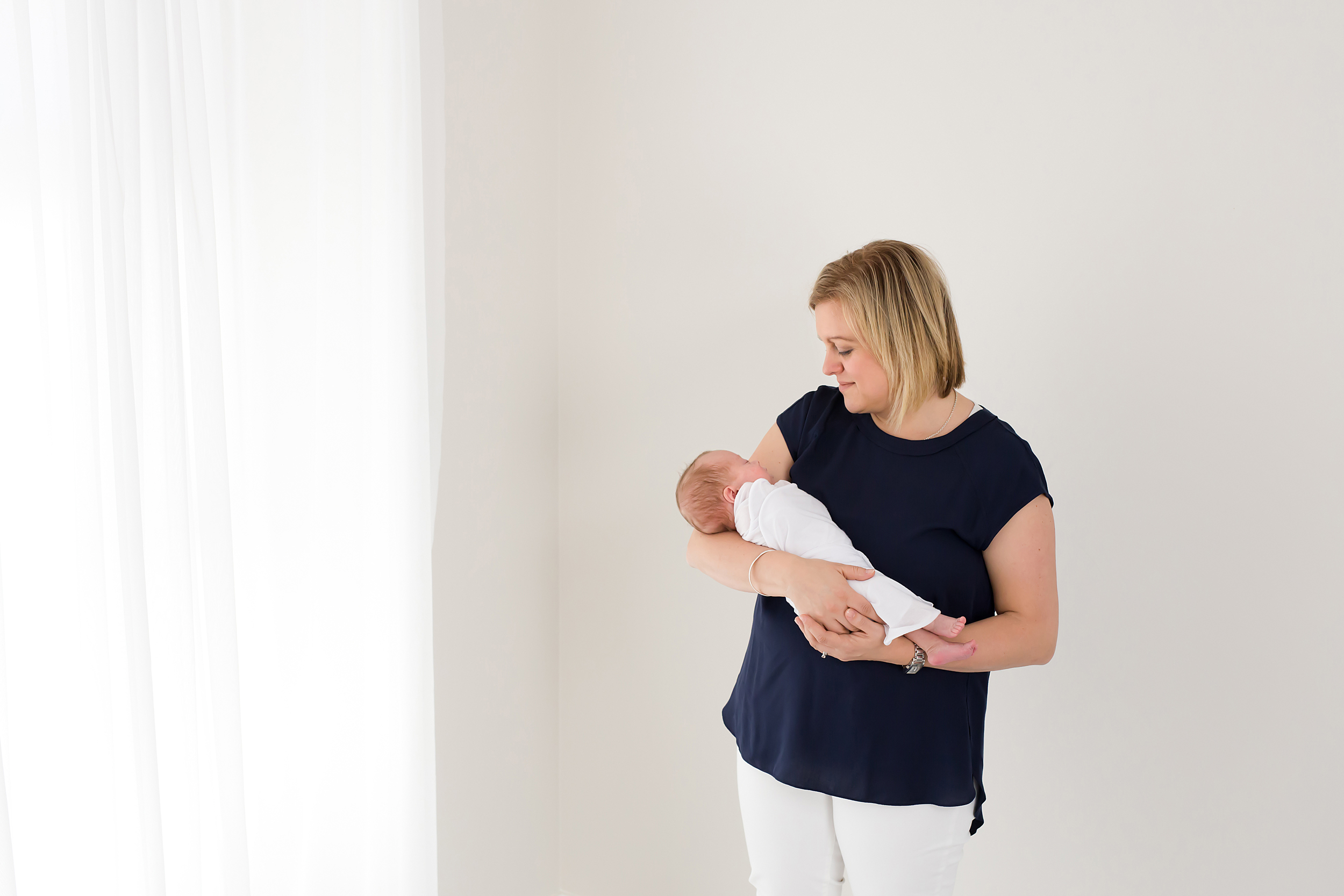 A photo of a Melbourne mum holding her newborn baby taken by a professional photographer in Melbourne