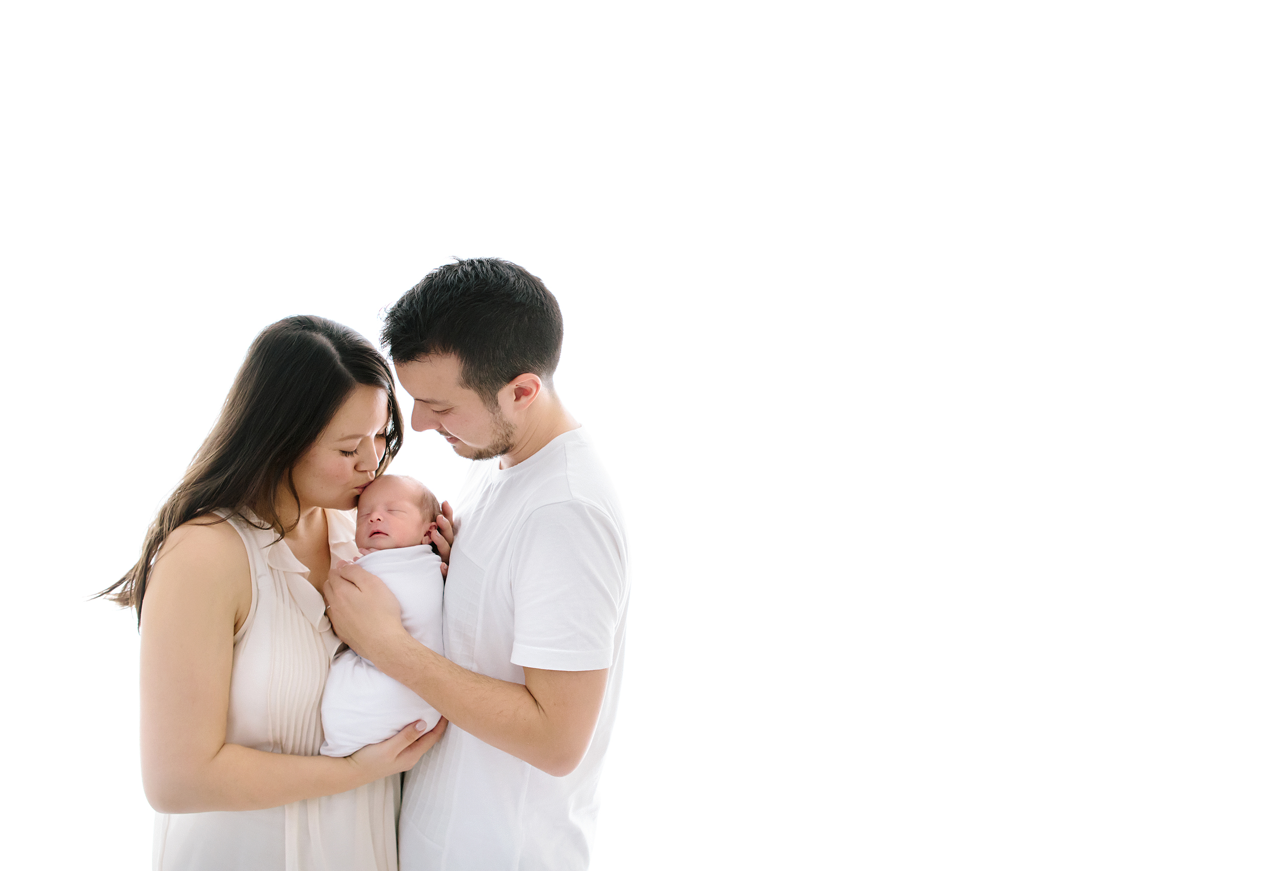 Couple holding their newborn baby boy while having baby photos taken by a professional photographer in Melbourne