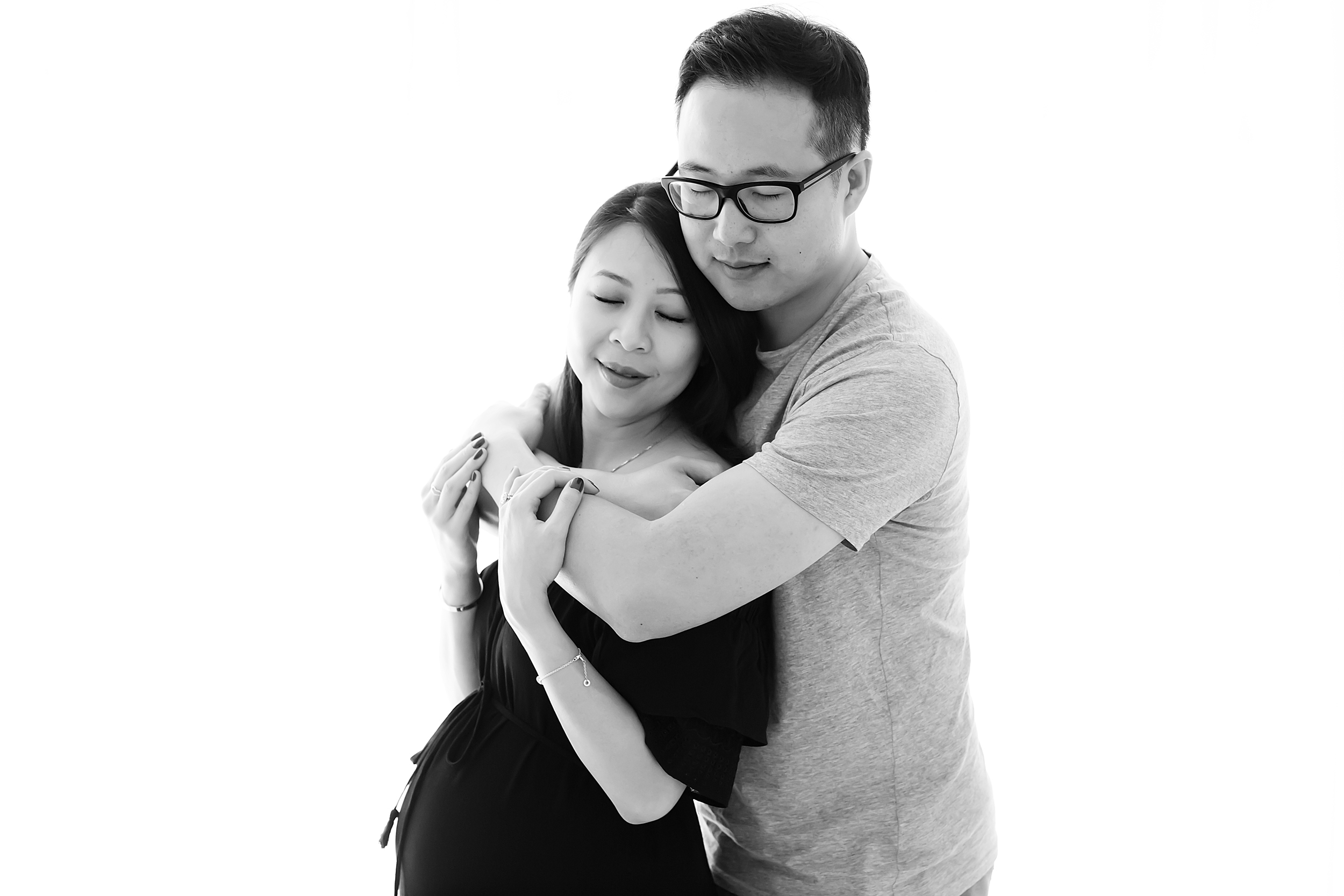 Black and white photo of couple embracing during their pregnancy photography session in Melbourne