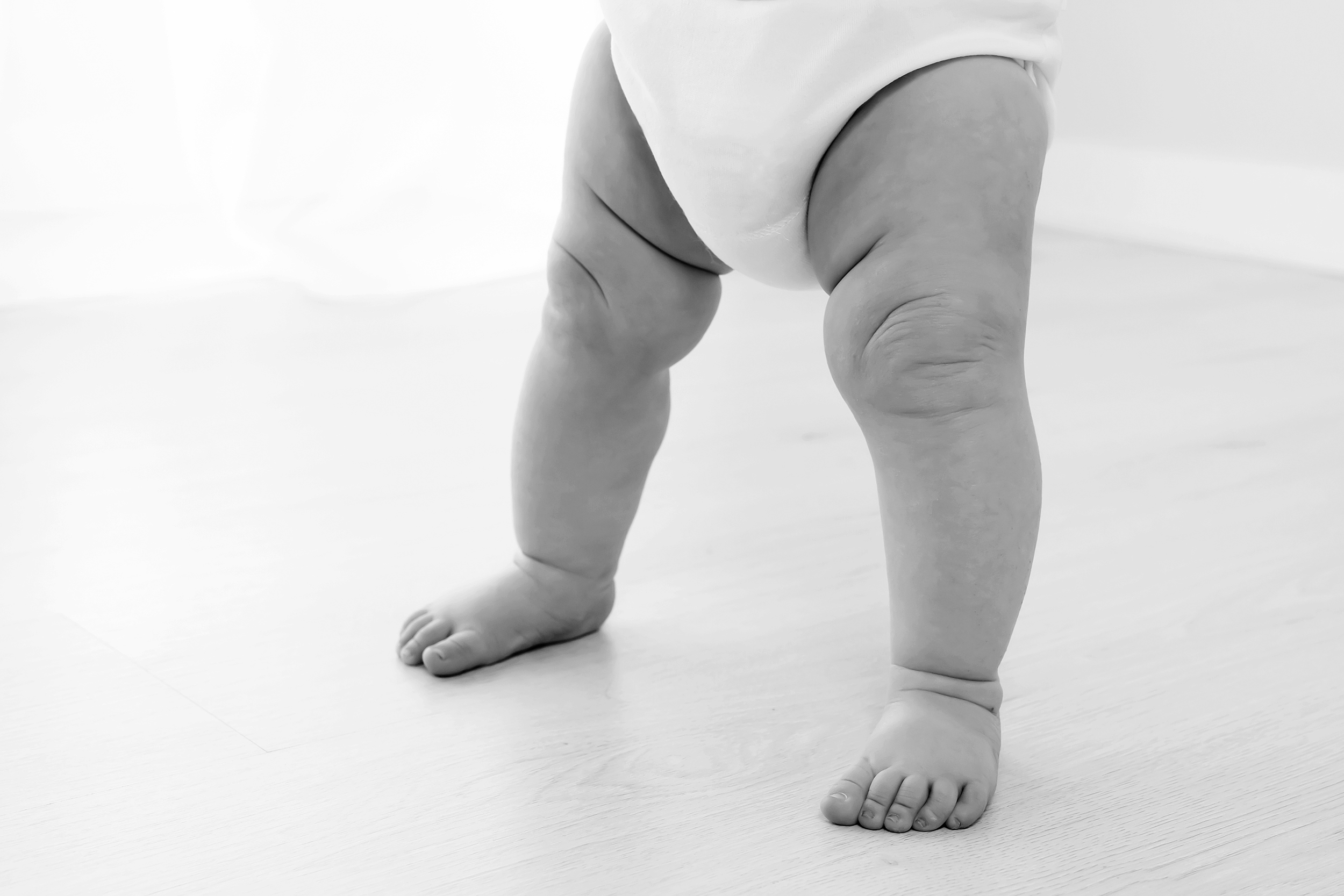 Close up black and white photo of baby legs during natural light baby photography session