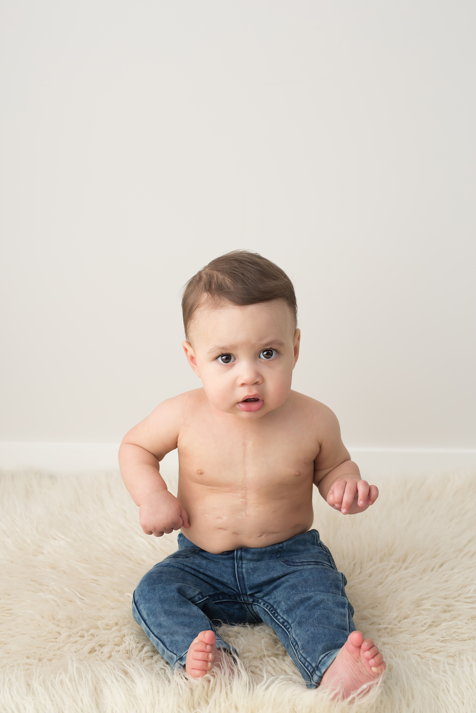Photo of toddler sitting down looking at the camera taken during baby photography session in Melbourne