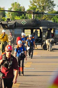 Rescuers unloading from a National Guard helicopter after flood deployment. Photo credit, Dave Zader.