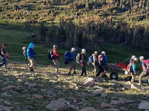 Rescuers performing wheeled trail carry evacuation of an injured hiker below St. Vrain Mountain, Indian Peaks Wilderness Area, August 7, 2014