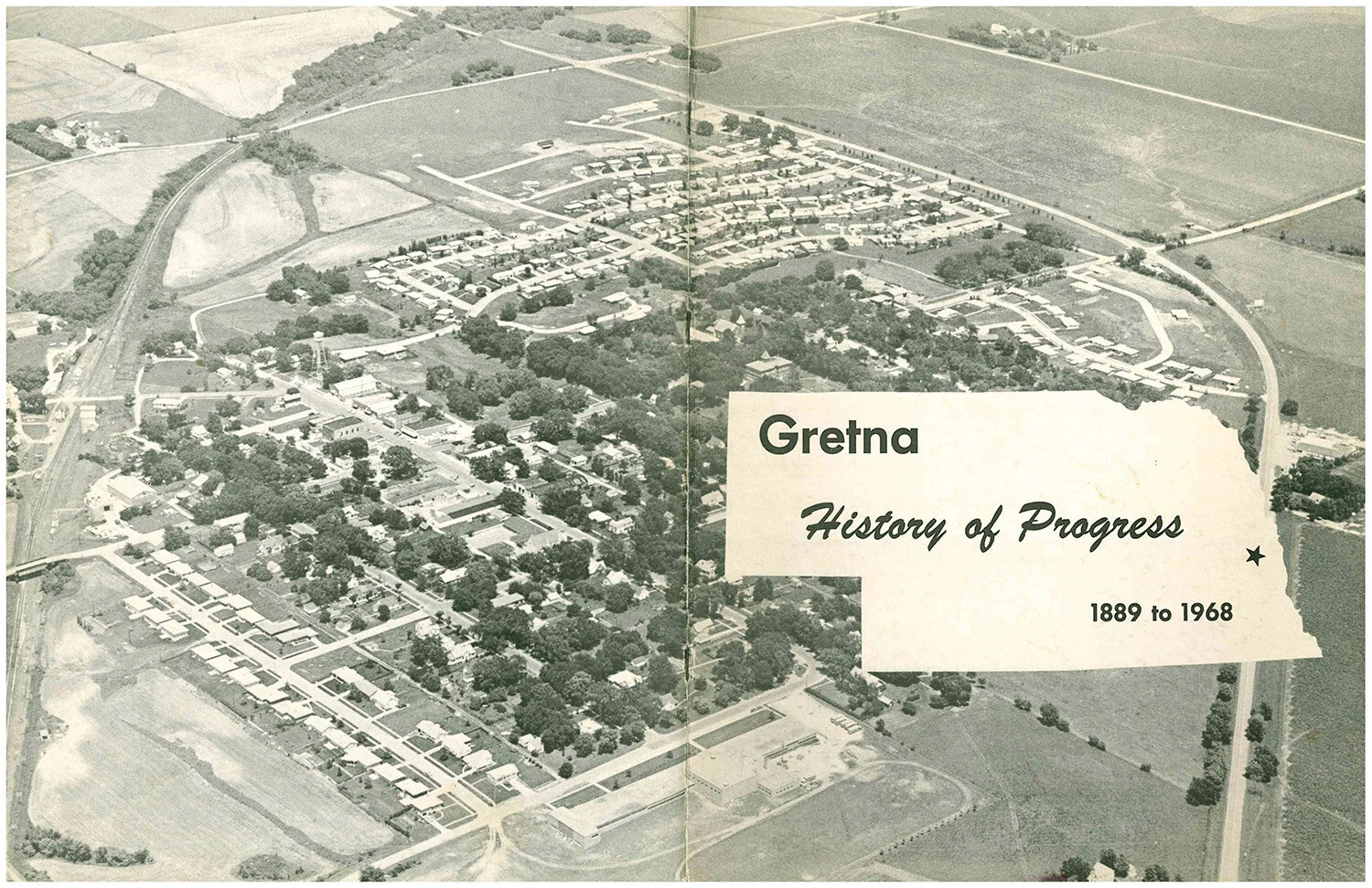 Vintage aerial photo of Gretna NE with "History of Progress" book cover, representing Gretna Sanitation's deep roots as a local, family-owned residential trash hauler in the community.