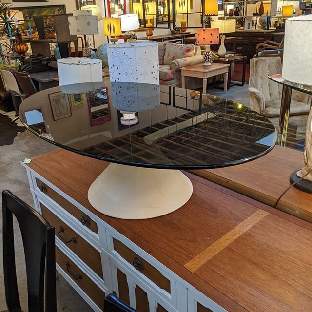 Smoked glass oval coffee table on a white tulip base. Stunning.