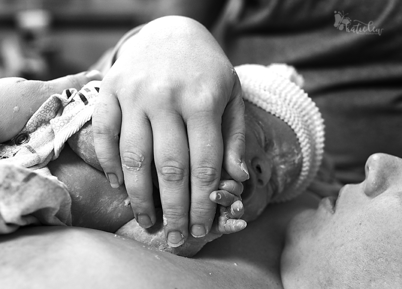 mom holds baby's hand after birth