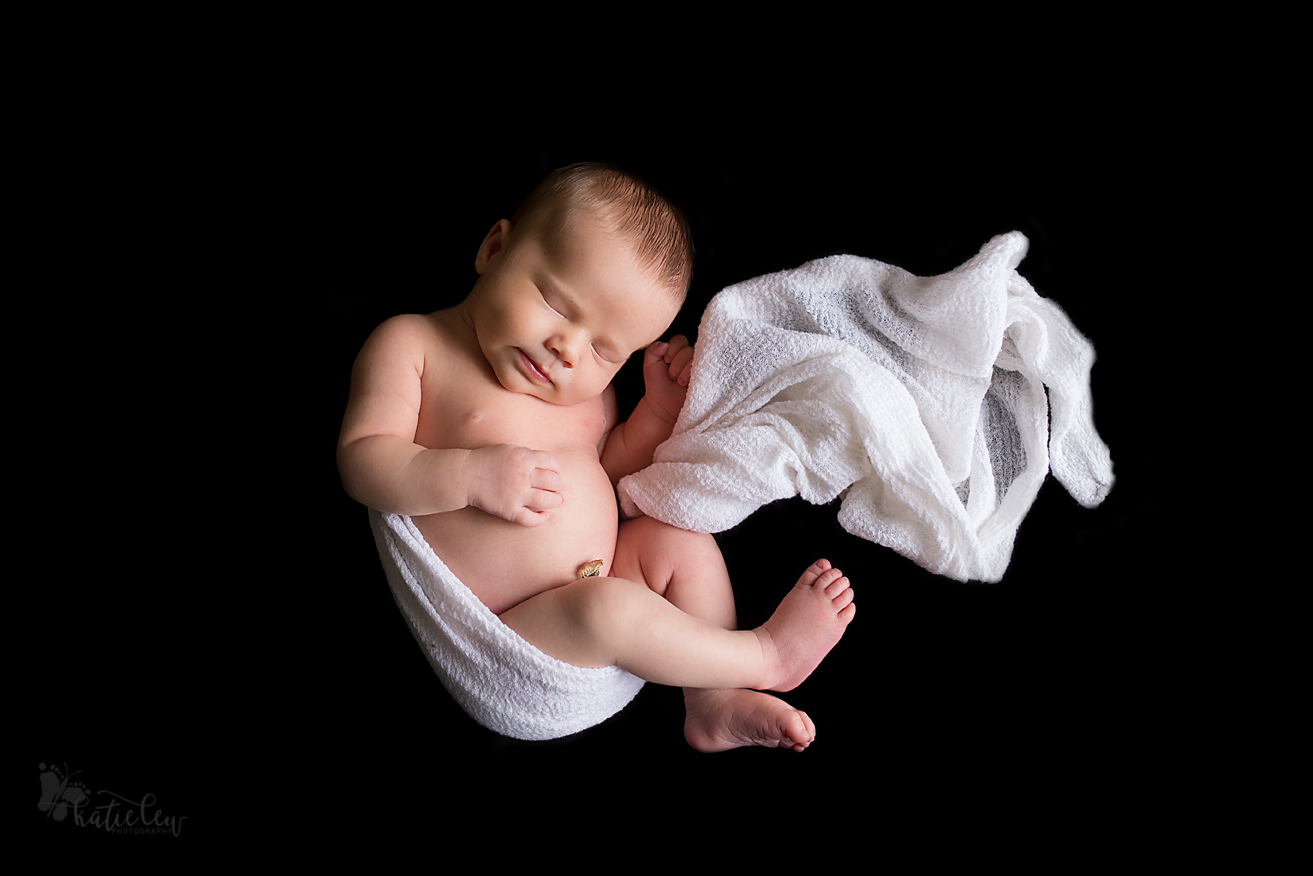 newborn boy on black background