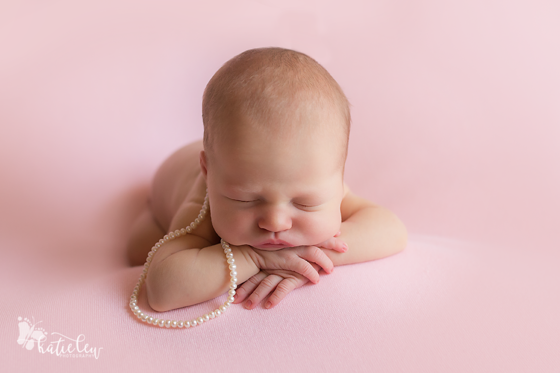 newborn girl with mommy's pearls