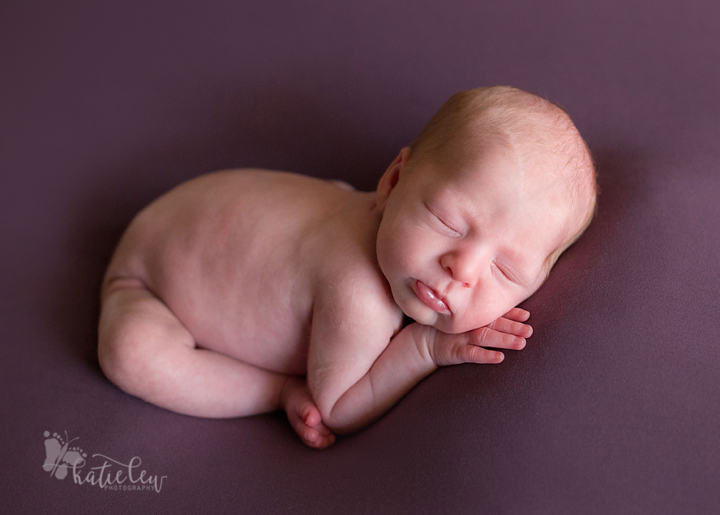 Baby girl lying on a purple blanket