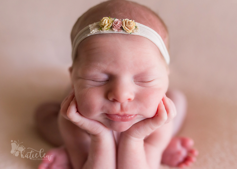 A close up of baby hannah in the head on hands pose