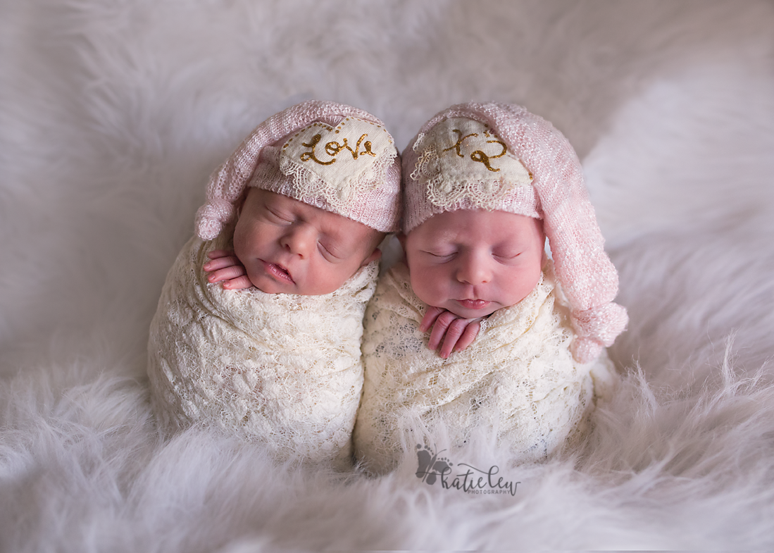 Twin baby girls with hats that say love times two