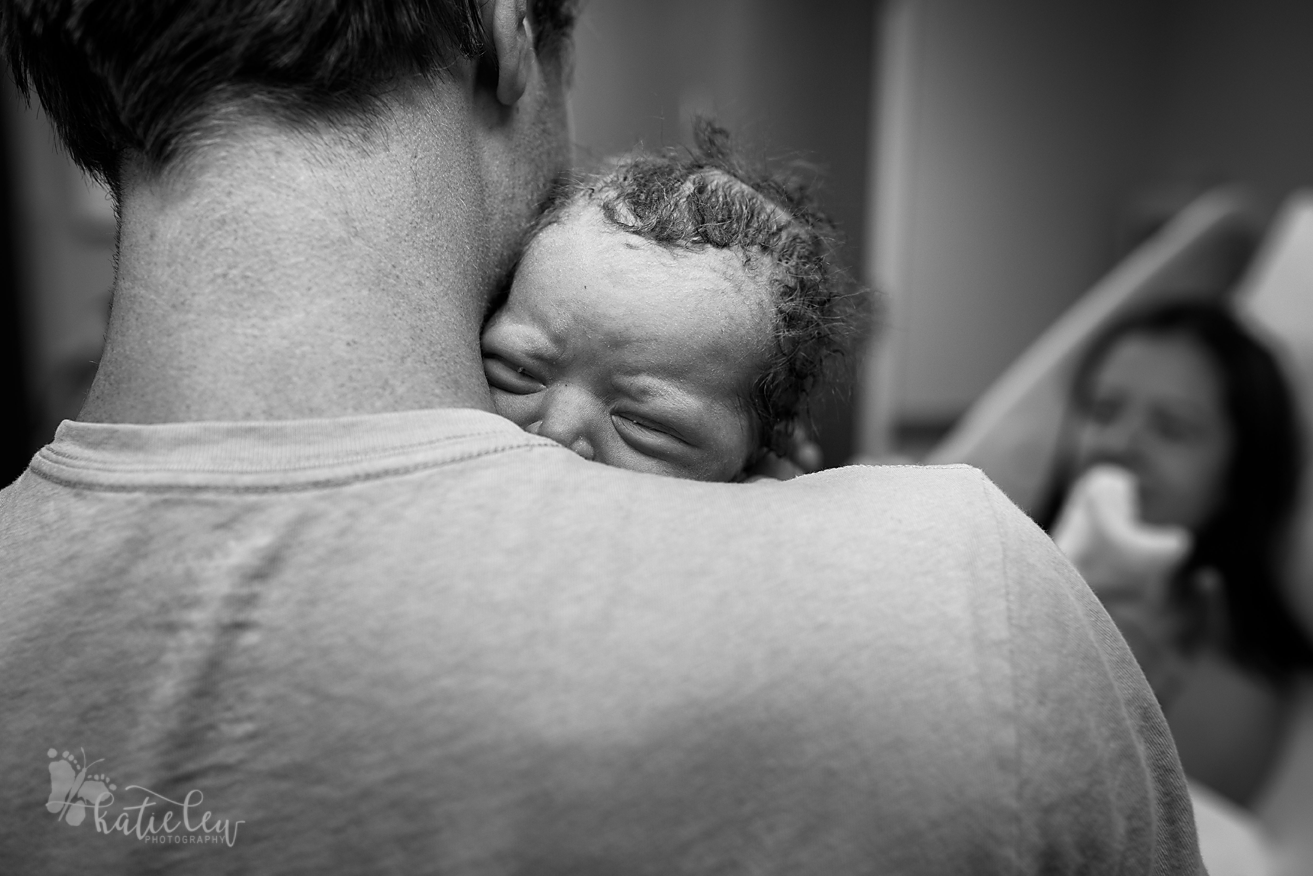 Dad holds his newborn daughter