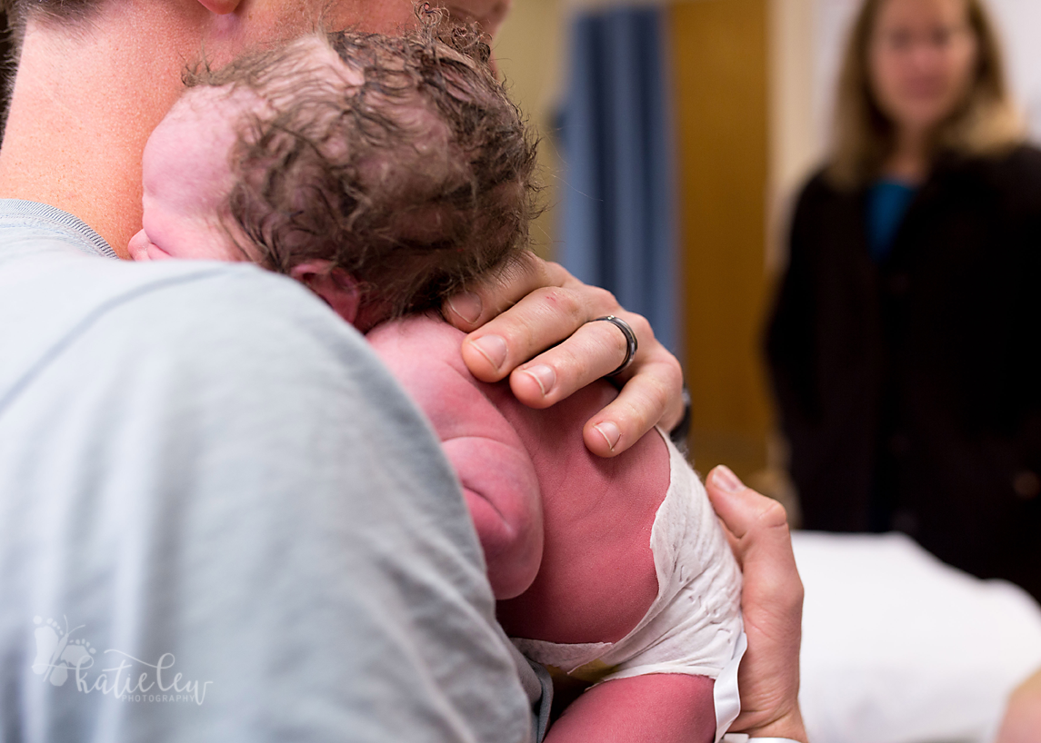 The dad holds his freshly newborn daughter at stillwater medical center