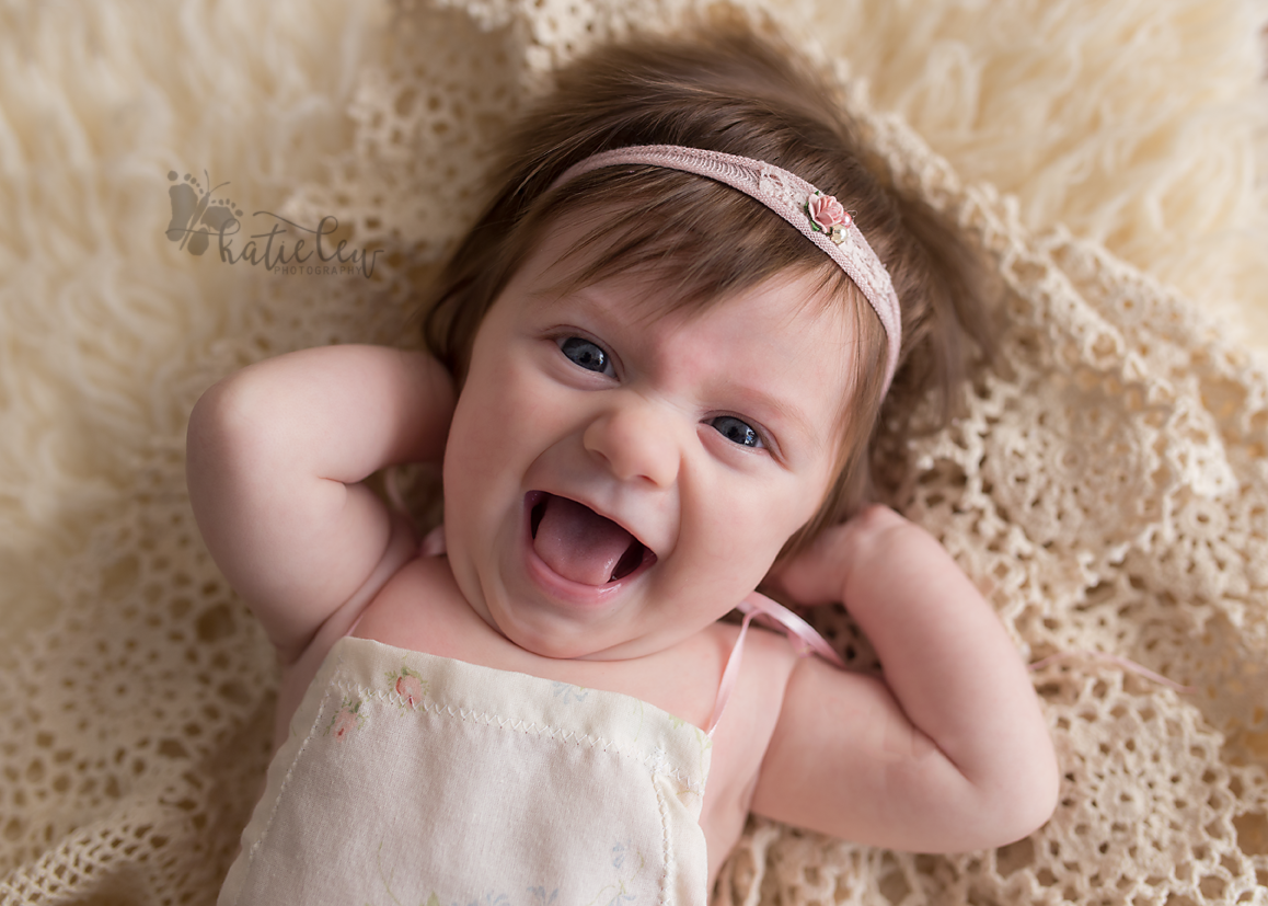 baby girl gives photographer a huge smile at her session in stillwater, oklahoma