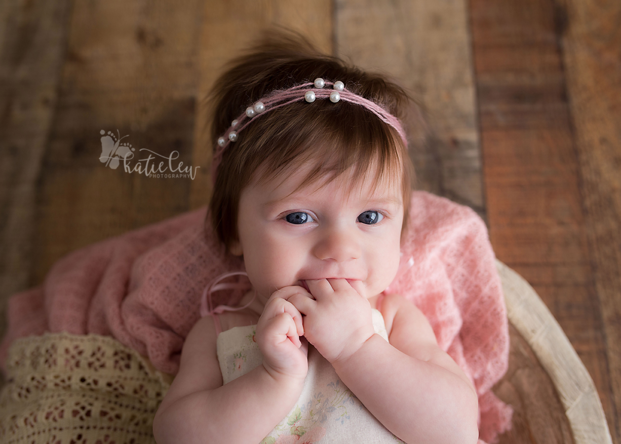 Baby girl loves chewing on her fingers at her photography session in stillwater, oklahoma