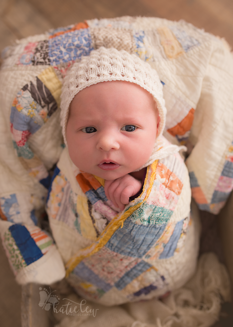newborn girl wrapped in a beautiful quilt