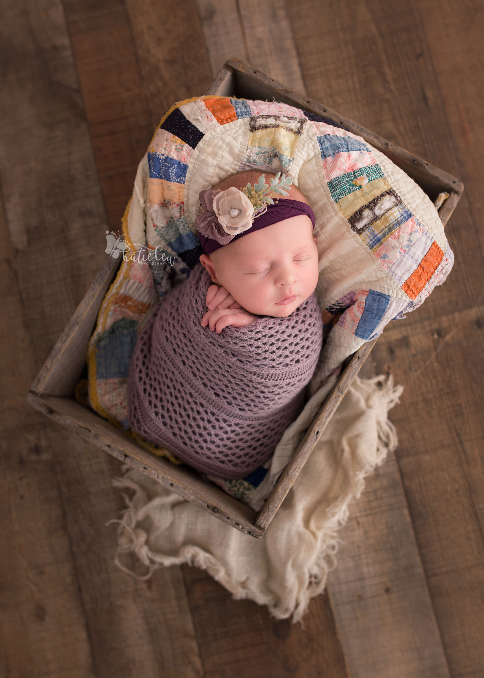 Tulsa newborn wrapped in purple and nestled in an old crate