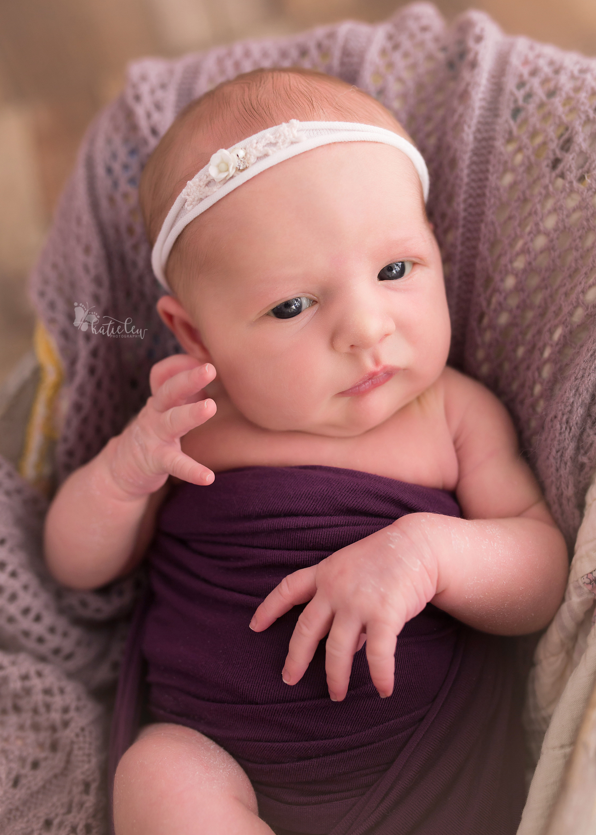 baby girl in purple with a white headband.