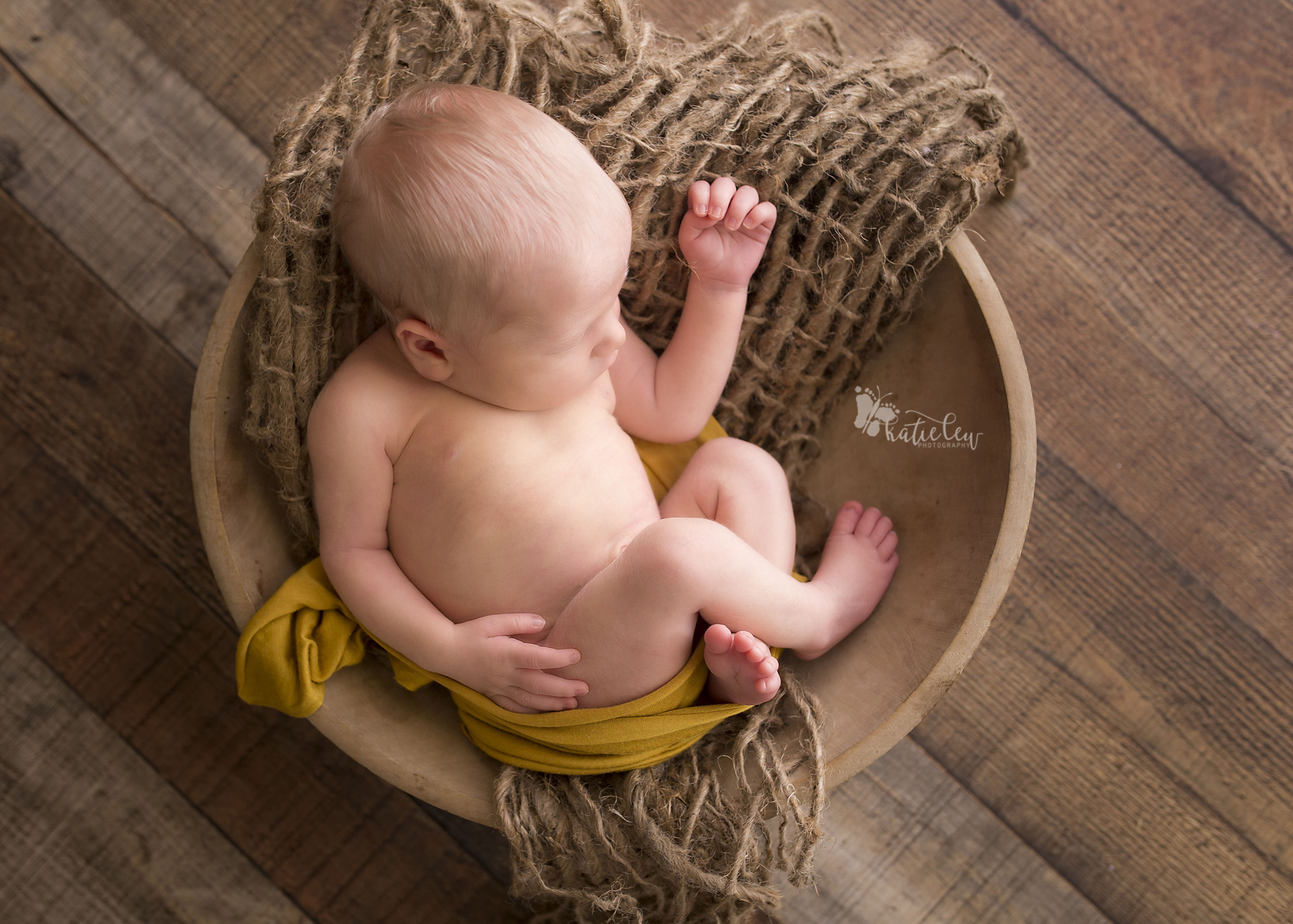 newborn baby boy sleeping and posed in a bowl
