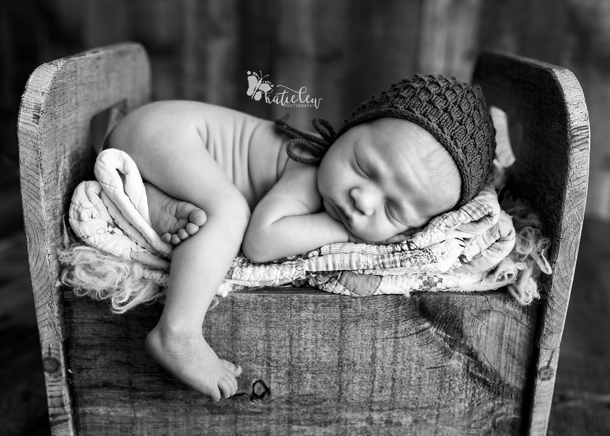 newborn baby boy laying on a bed of soft quilts