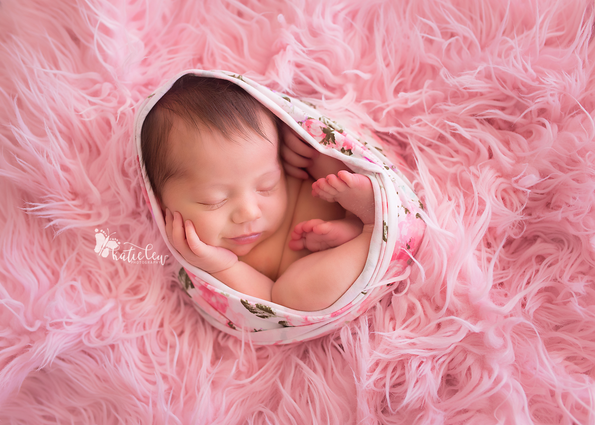 baby girl smiling and nestled in pink fur